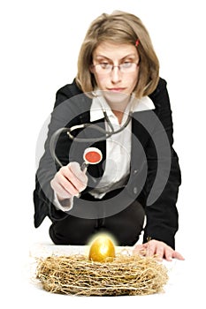 Woman studying a golden egg.