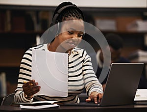 Woman, studying and headphones in library for research, documents and computer research or planning in university