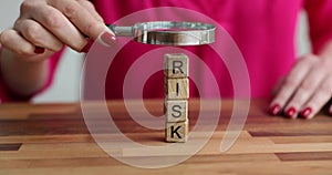 Woman is studying letter of word risk with magnifying glass