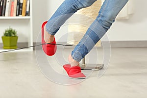 Woman stumbling with an electrical cord at home photo