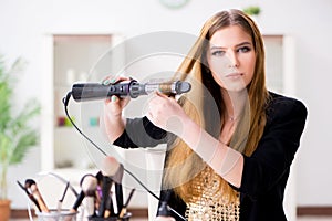 The woman styling her hair with hairdryer