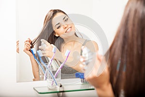 Woman styling her hair with spray