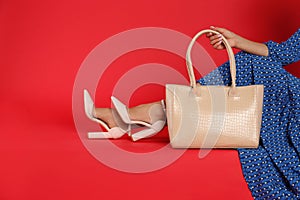 Woman with stylish bag on red background, closeup