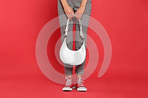 Woman with stylish bag on red background, closeup