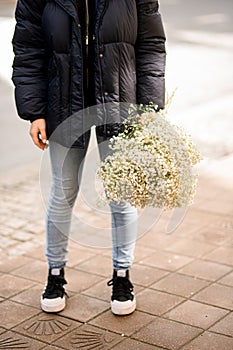 woman with stylish large bouquet of white gypsophila outside during the day