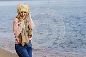Woman in stylish outfit feeling cold by the sea