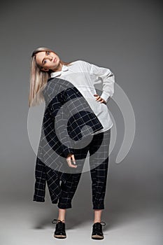 Woman in stylish outfit standing in studio