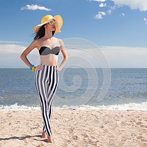 Woman in stylish swimsuit on beach