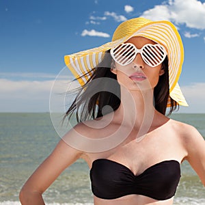 Woman in stylish swimsuit on beach