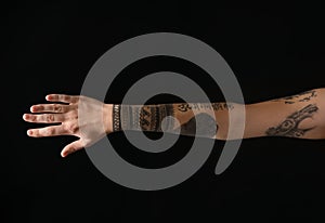 Woman with stylish tattoos on arm against background, closeup
