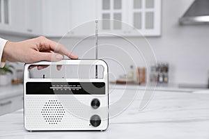 Woman with stylish white radio in kitchen, closeup. Space for text