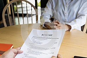 Woman submits job application, Interviewer reading a resume.