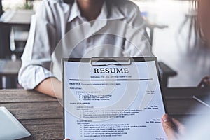 Woman submits job application, Interviewer reading a resume