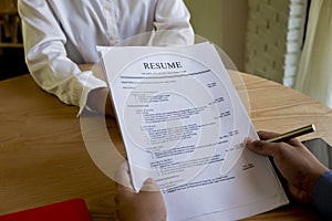 Woman submits job application, Interviewer reading a resume. photo