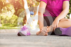 Woman suffering from an ankle injury while exercising.