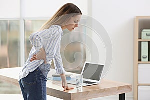 Woman suffering from back pain. Symptom of bad posture