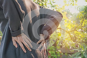 A woman suffering from backache, spinal injury and muscle issue