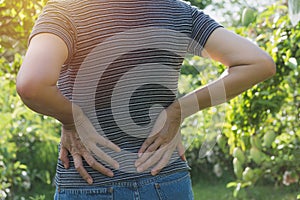 A woman suffering from backache, spinal injury and muscle issue