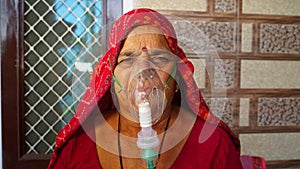 Woman suffering from Covid 19 disease. Old woman admitted in hospital and inhaling emergency oxygen with canula mask