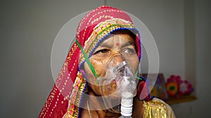 Woman suffering from Covid 19 disease. Old woman admitted in hospital and inhaling emergency oxygen with canula mask