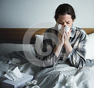 A woman suffering from flu in bed