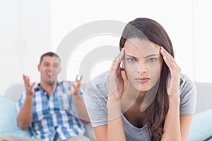 Woman suffering from headache while man arguing