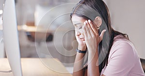 Woman suffering from a headache or migraine while working on desktop computer in an office at work. Upset and stressed