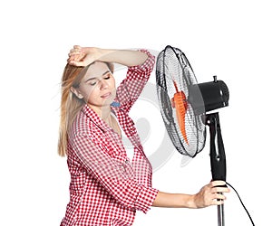 Woman suffering from heat in front of fan