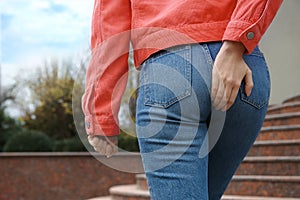Woman suffering from hemorrhoid pain outdoors
