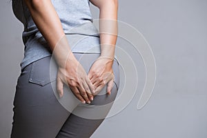 Woman suffering from hemorrhoids and hand holding her bottom because having Abdominal pain. Health care concept