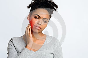 Woman suffering from inflamed gums, grey background