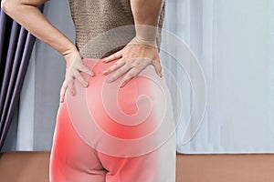 woman suffering from lower back and buttock pain spreading to down leg, Sciatica Pain concept photo