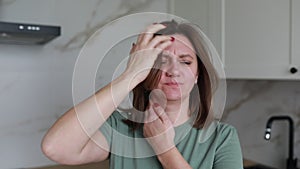 Woman Suffering From Neck Pain In Her Modern Kitchen During Morning Routine