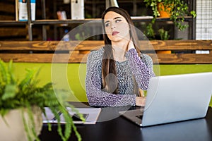 Woman suffering from neck pain in office