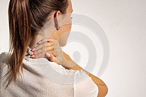 Woman suffering from neck or shoulder pain. Female massaging her neck