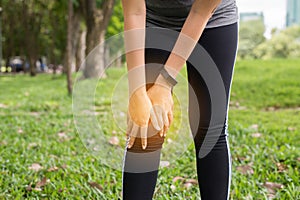 Woman suffering from pain in leg and knee injury after sport exercise running jogging and workout outdoor