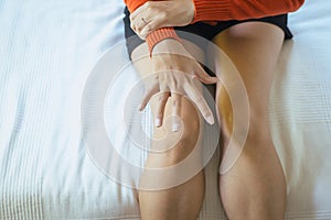 Woman suffering with parkinson`s disease symptoms in bedroom on white background and copy space