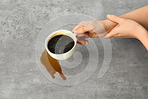 Woman suffering from Parkinson syndrome with cup of coffee