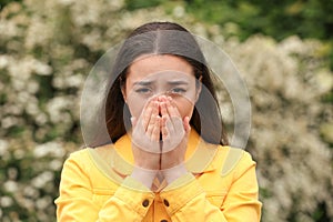 Woman suffering from seasonal spring allergy outdoors