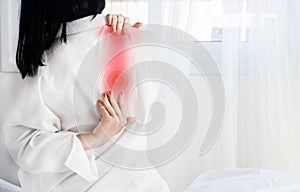 Woman suffering from shoulder blade pain after sleeping on it wrong