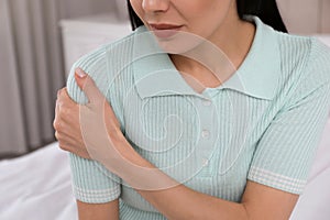 Woman suffering from shoulder pain at home