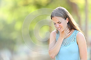 Woman suffering sore throat in a park photo