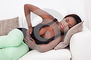 Woman suffering from stomachache at home photo