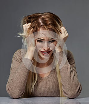 Woman suffering from stress or headache while being offended by pain,