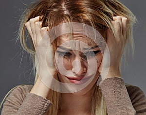 Woman suffering from stress or headache while being offended by pain,
