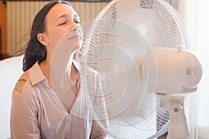 Woman suffering for summer heat refreshing at home