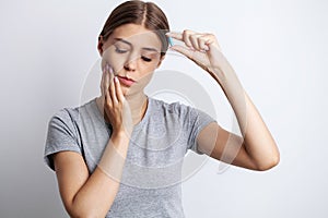 Woman suffering from tooth pain and touching cheek