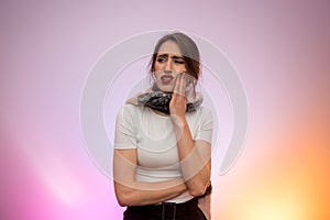 Woman suffering with toothache. She`s holding her hand on face and feeling pain