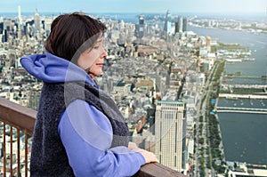 Woman suffers from acrophobia on the viewing platform above a big city