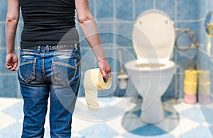 Woman suffers from diarrhea holds toilet paper in hand in toilet.